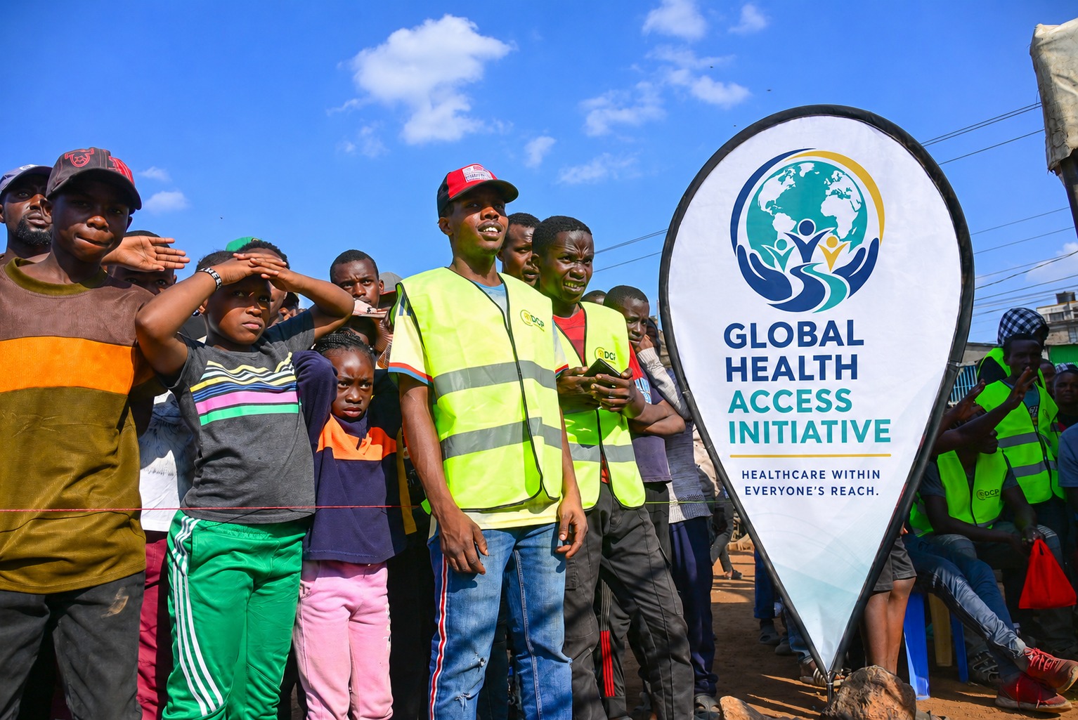 GHAI community outreach event with branded banner and local community members